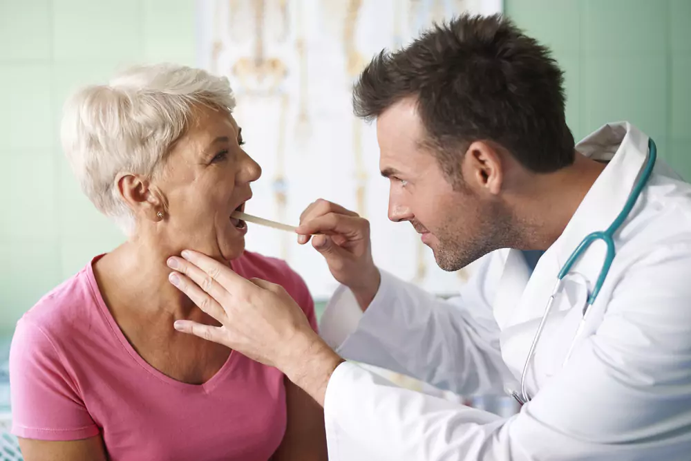 Doctor Checking Throat Senior Woman