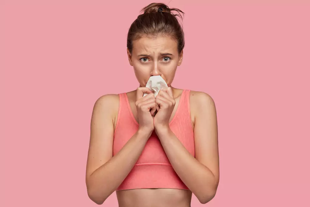 Young Woman Attempting To Stop Nosebleed